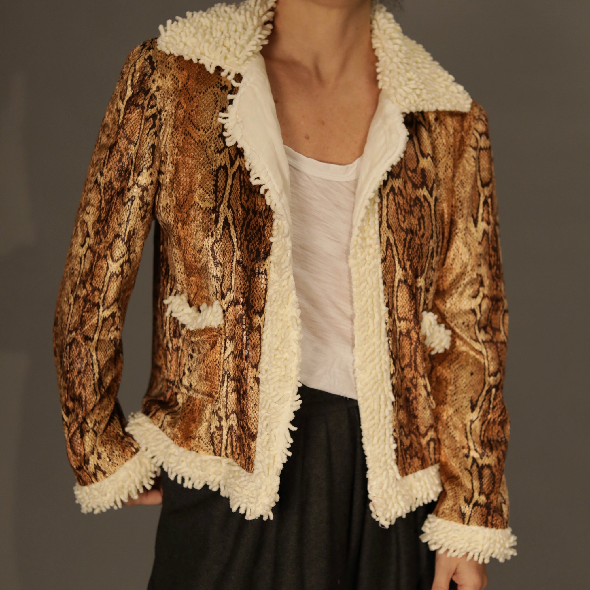 Editorial close-up of the jacket’s python texture and cream shag hem, emphasizing craftsmanship.
