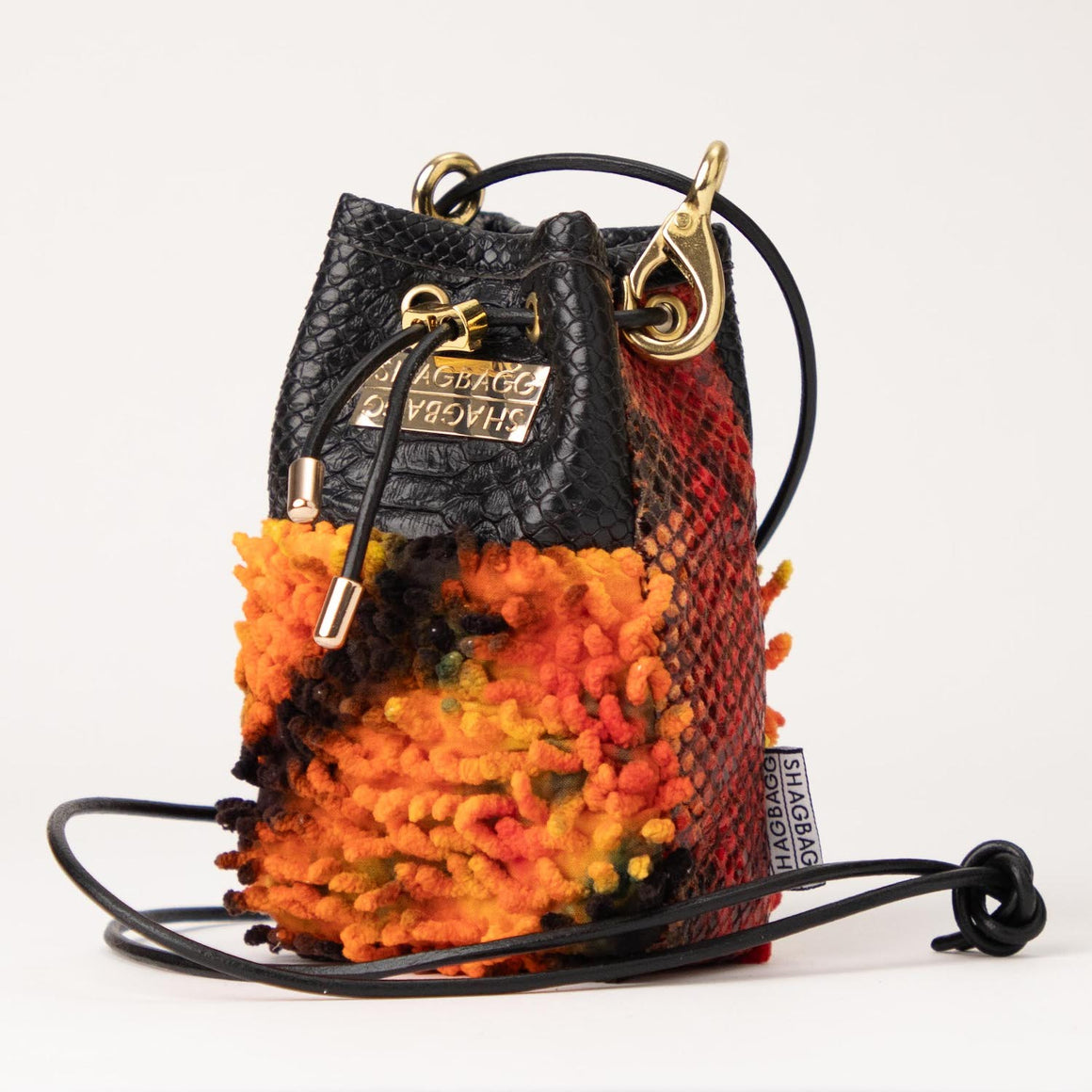 Multicolored textured bag with black drawstring on a white background