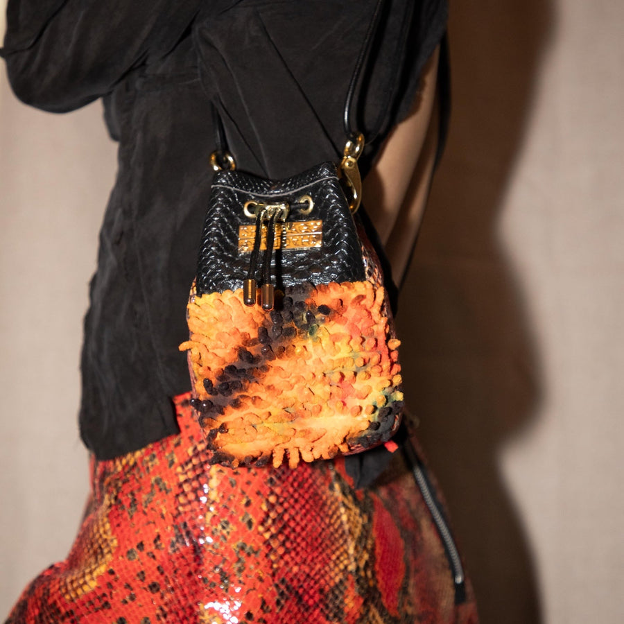 Multicolored textured bag with black drawstring on a white background