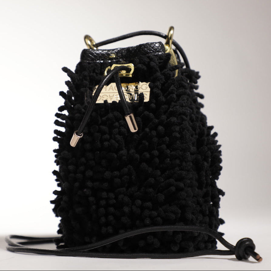 Black textured mini handbag with gold hardware worn crossbody with interior zipper pocket detail