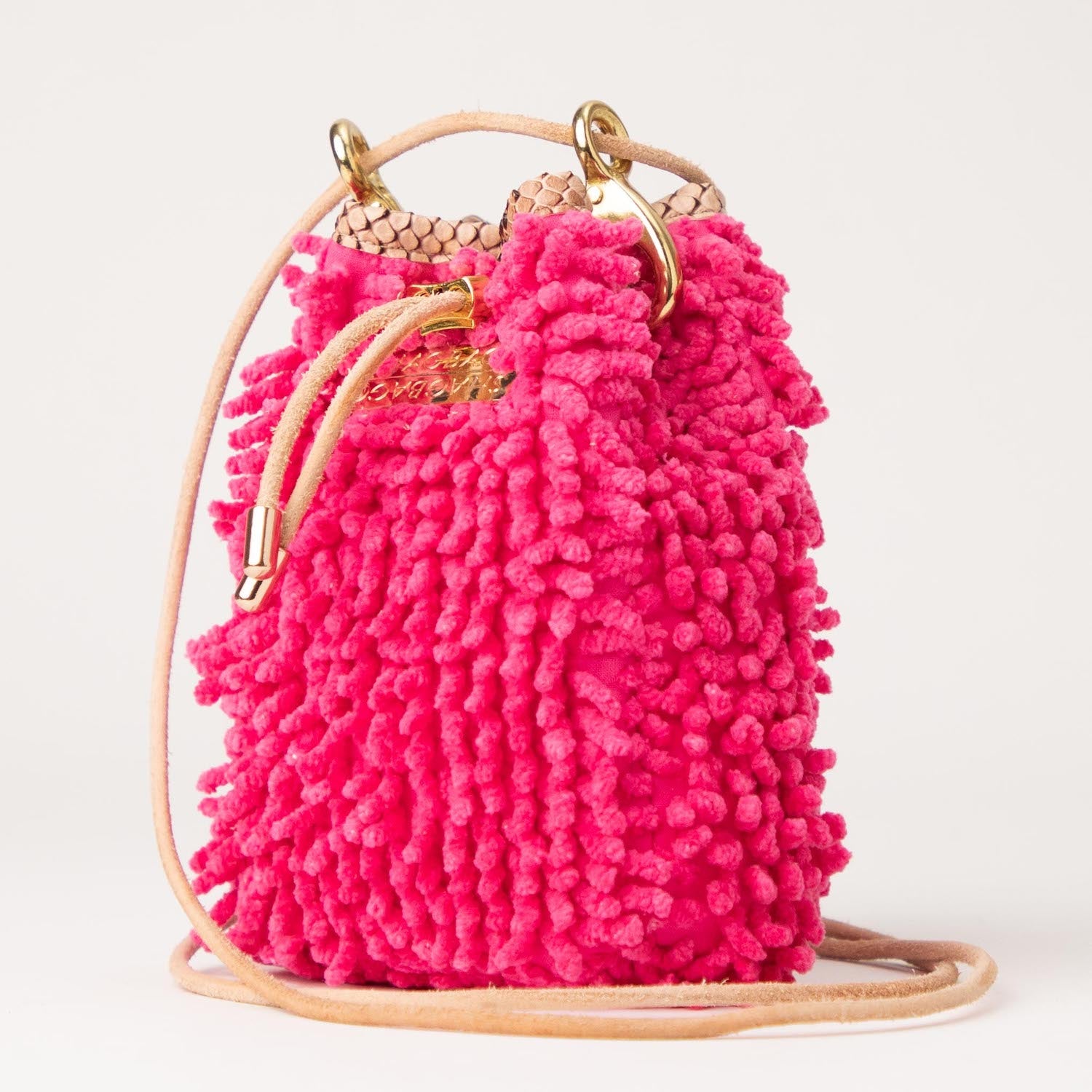 Pink fluffy handbag with gold handles on a white background