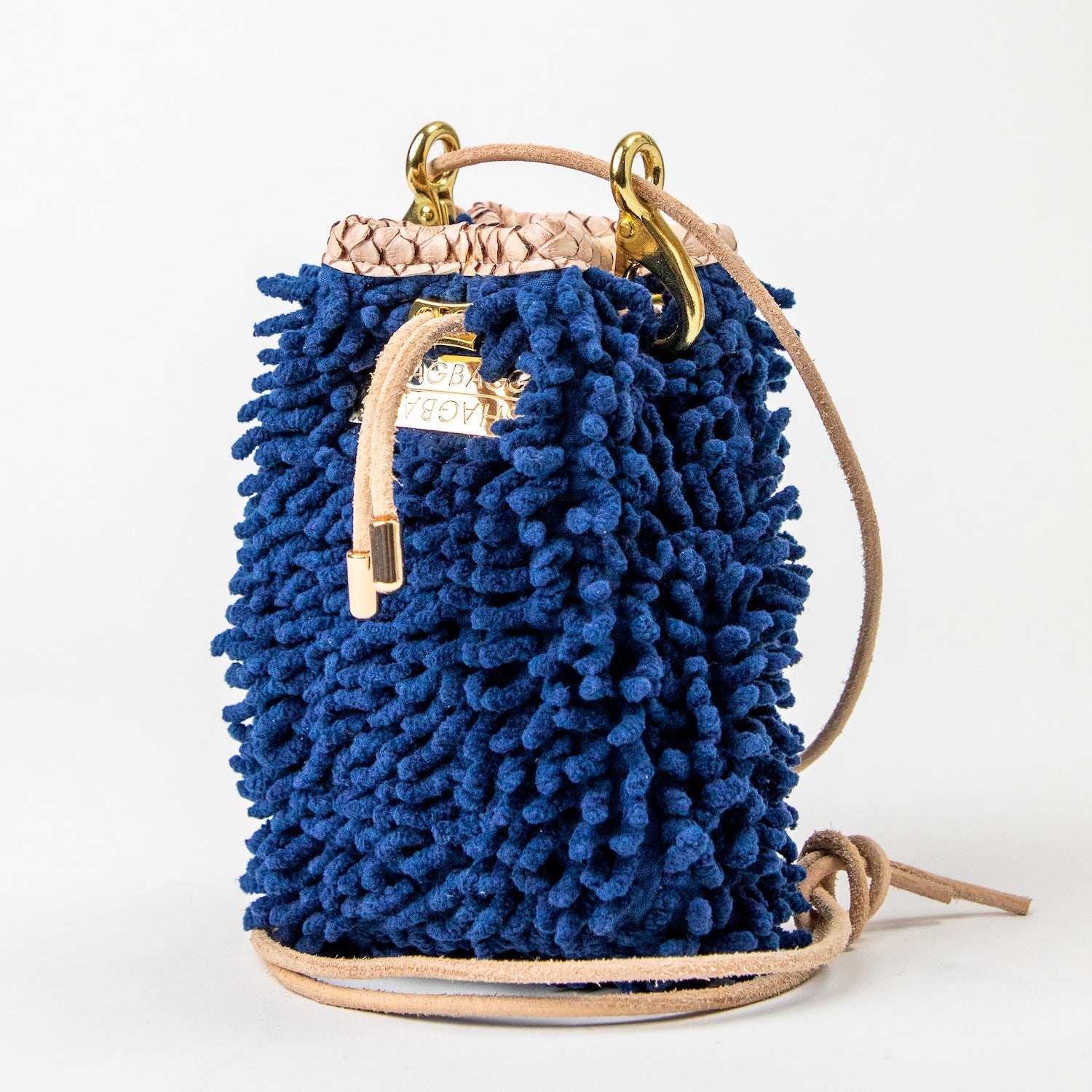 SHAGBAGG Drawstring Mini — Navy full SHAG crossbody bag with tan suede base and gold hardware, handmade Hollywood Los Angeles, front view