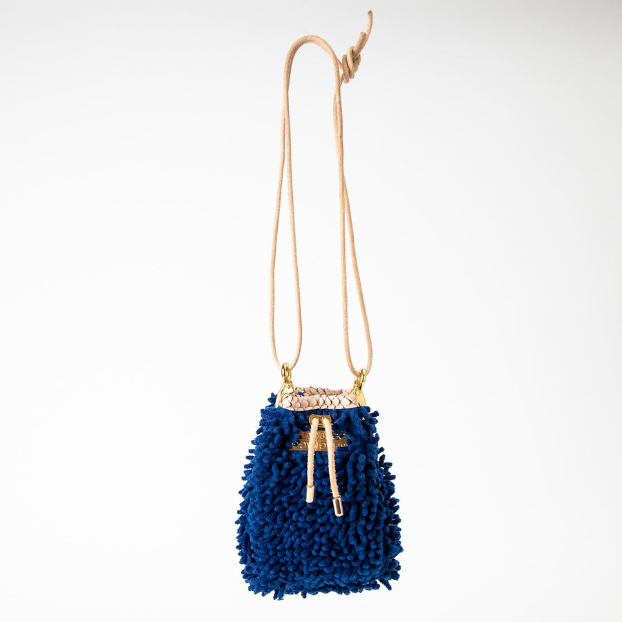 SHAGBAGG Drawstring Mini — Navy full SHAG crossbody bag with tan suede base and gold hardware, handmade Hollywood Los Angeles, front view