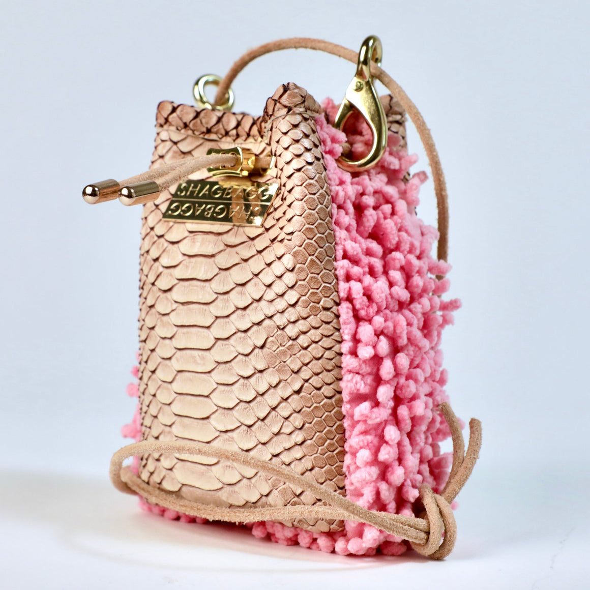 Rose Ranch Drawstring SHAG Mini shown with its full natural leather cord strap, featuring rose pink SHAG, tan faux python, and gold-tone hardware.