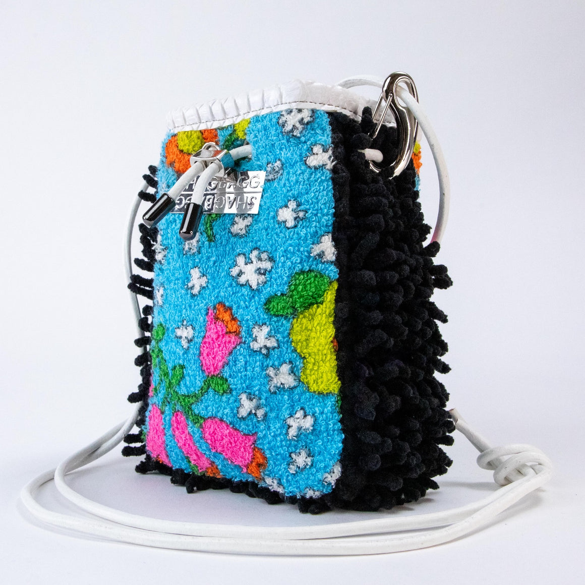 Trippy Garden at Midnight Drawstring SHAG Mini featuring archival turquoise floral terry, black SHAG, white faux python trim, silver-tone hardware, and a white leather cord strap, handcrafted in Los Angeles.